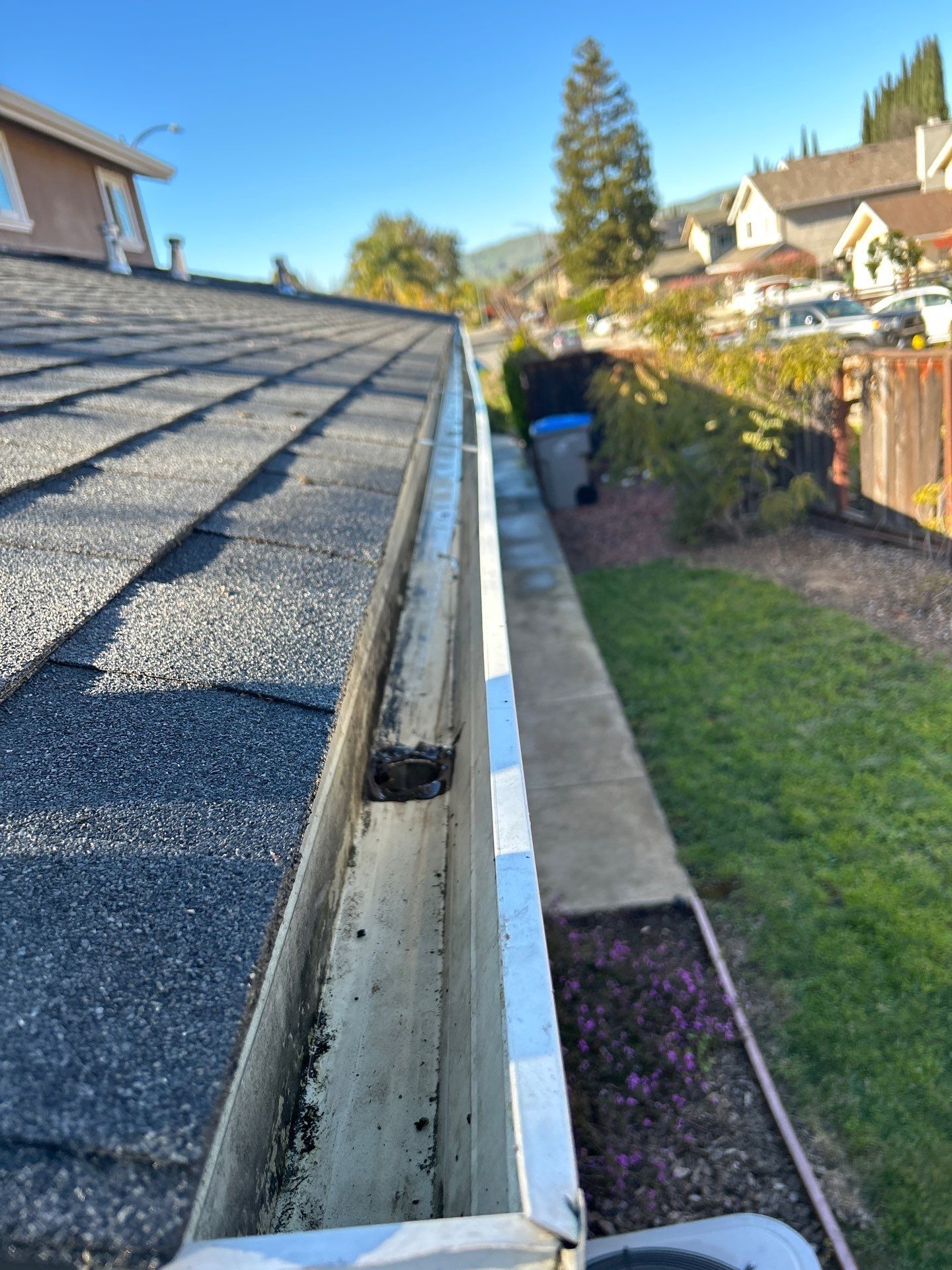 Clear residential gutter with neighborhood view